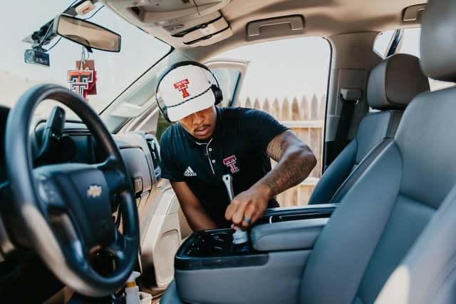 Elijah detailing the interior of a pickup truck on site, Lubbock